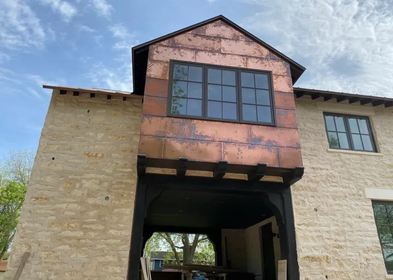 Copper metal panel facade on a stone building for Roof Repair in Coldwater
